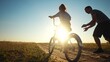 © maxximmm - dad teaches daughter to ride a bike. happy family childhood dream concept. father and little daughter learn to ride a bike silhouette in the park. happy family goes in for sunlight sports outdoors