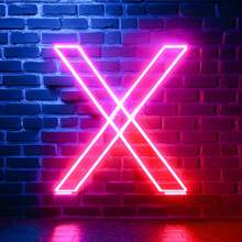 Neon Letter X On A Brick Wall Background.
