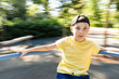 © RooM The Agency - Boy spinning around on a carousel in a park in summer, Georgia