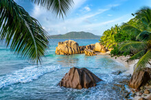 Granite Rocks And Palm Trees On The Scenic Tropical Sandy Anse Patates Beach, La Digue Island, Seychelles