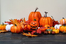 Close-up Of An Autumnal Halloween Decoration With Assorted Pumpkins, Autumn Leaves And A Jack-o-lantern