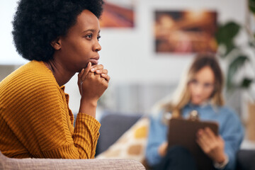 Mental health, anxiety and psychology with a black woman in therapy, talking to a professional. Depression, stress or support with a young patient in session with a psychologist for grief counseling