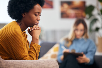 Mental health, depression and psychology with a black woman in therapy, talking to a professional. Anxiety, stress or support with a young patient in session with a psychologist for grief counseling