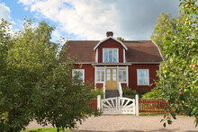 A Typical Red And White Swedish House In Smalland. White Garden Gate, Brown Fence