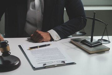 Business and lawyers discussing contract papers with brass scale on desk in office. Law, legal services, advice, justice and law concept picture with film grain effect