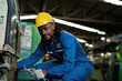 © KANGWANS - Black male African American worker is working in an industrial factory. manufacturing industry concept Machinery in the factory Metal grinder in factory