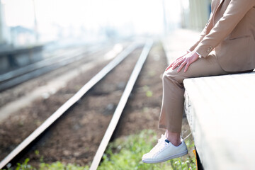 A man sitting on the edge of the train platform with copy space for text. Depression awareness. 