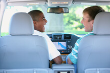 Two Teenage Boys Sitting And Laughing In The Front Seat Of A Car; Troutdale, Oregon, United States Of America