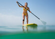 © Designpics - A woman in a yellow bikini paddles on a yellow board; Tarifa cadiz andalusia spain