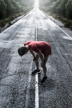A Runner Stops To Take A Break On A Wet Road; Tarifa Cadiz Andalusia Spain