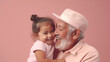 © Ai Studio - A Heartwarming Capture: Proud Hispanic Senior Grandfather Sharing an Unforgettable, Special Moment with His Adorable Grandchild, Set Against a Soft Pastel Pink Background.