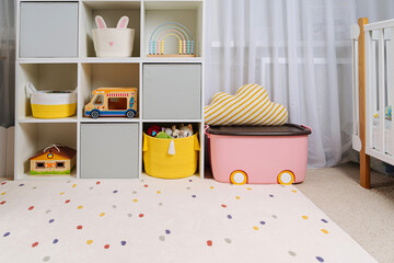 Wall Mural - White shelving with colorful storage baskets and boxes with toys. Interior design. Organizing and storage ideas in children room. Interior design. Playroom