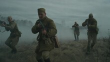 Slow Motion Tracking Shot Of Male Reenactors Wearing Soviet Red Army Uniforms Performing Offensive