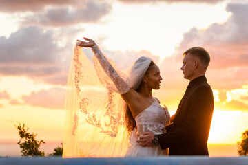 Wall Mural - Portrait of newlyweds in the rays of the setting sun