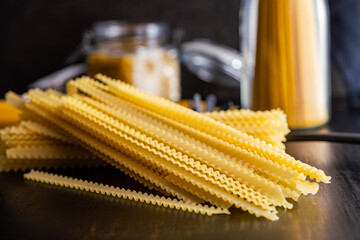 Wall Mural - Mafaldine pasta. Uncooked italian pasta on black table.