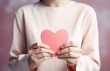 © olegganko - asian woman making heart shape with hands on pink background.