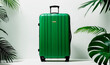 Green travel suitcase on white background with exotic plants