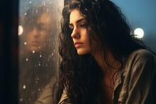 Sad And Lonely Latin Girl Sitting On The Window Watching The Raindrops Fall