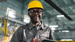 © ihorvsn - African American architecor in protective casque hold tablet. Male engineer is posing and smiling at camera. Worker at background of construction sity. Variety of industrial professions.