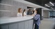 © Framestock - Adult woman stands at reception desk in clinic lobby entrance and makes appointment with doctor. Female administrator talks with patient at information counter. Medical staff work in modern hospital.
