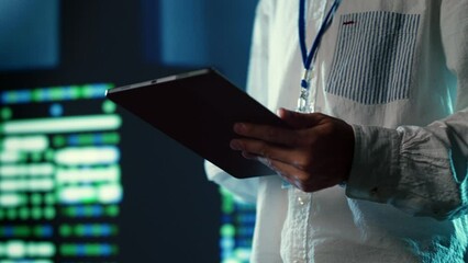 Poster - Efficient employee walking through data center units providing processing resources for different workloads. Admin troubleshooting server rigs tasked with solving complex operations, close up