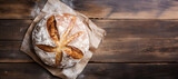 Fototapeta  - a loaf of freshly baked sourdough bread on a wooden table, banner with copy space