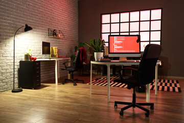 Interior of dark office with programmer's workplaces