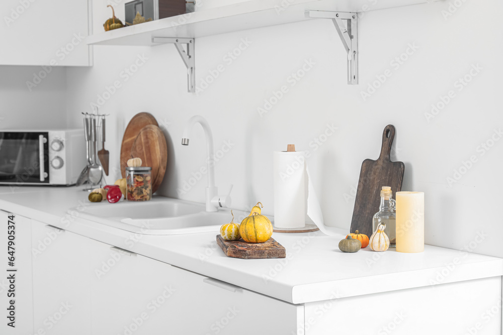 Halloween pumpkins with utensils on counter in kitchen
