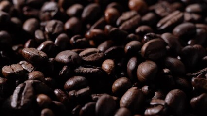 Wall Mural - Close-up video of roasted coffee beans. Moving sideways. Dropping coffee beans.