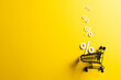 Shopping trolley and white percent signs with copy space on yellow background