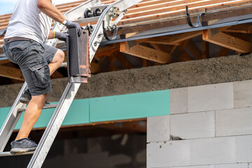 Wall Mural - a worker carries a ceramic tile up the stairs to the roof