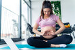 © DusanJelicic - young pregnant woman siting on a yoga mat making a heart shape on her pregnant belly, excited young mother concept