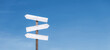 Blank wooden sign against the sky. Direction signpost on a blue horizontal background. The right path and wrong way. Guidance concept.