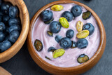 Fototapeta Kwiaty - fresh blueberry-flavored yogurt with ripe blueberries and pistachios