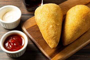 Wall Mural - two traditional Brazilian coxinhas. typical fried snack food stuffed with meat and chicken