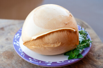 Ball of smoked Italian soft cheese Mozzarella di Bufala Campana served with fresh green basil and red sicilian tomatoes