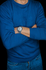 Canvas Print - Man posing idly by with a wristwatch in a blue sweater, fashion and style of clothing on a dark background