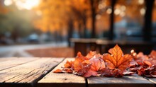 Autumn Yellow Leaves On A Wooden Table Against The Background Of A Blurred Image Of An Autumn Landscape On A Sunny Day