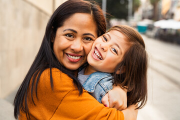 happy southeast asian mother with her daughter having fun in the city center - lovely family outdoor
