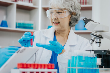 Wall Mural - Two Asian scientists in the laboratory or medical personnel looking at a microscope in the lab