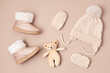 Collection of cute baby clothes and booties. Warm hat, mittens and boots for cold weather of fall and winter season. Newborn gifts for Christmas and baby shower, donation idea.