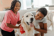 Portrait happy children, African American brother and sister stroking and playing with golden retriever dog