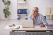 © Elnur - Old male employee working at workplace