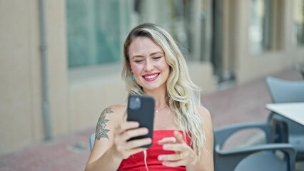 Sticker - Young blonde woman making selfie by the smartphone sitting on table smiling at coffee shop terrace