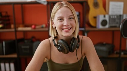 Canvas Print - Young blonde woman musician wearing headphones smiling at podcast studio