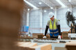© 2B - A male employee is using a machine to sew cardboard boxes in a warehouse. and arrange cardboard boxes