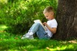 © BillionPhotos.com - School girl listening book in park. Concept of distance learning.