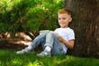 © BillionPhotos.com - School girl listening book in park. Concept of distance learning.