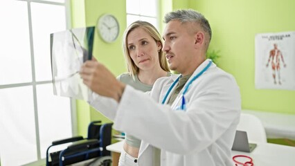 Poster - Man and woman doctor and patient having medical consultation looking xray at the clinic