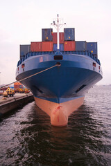 Front view of moored container ship loaded with shipping containers